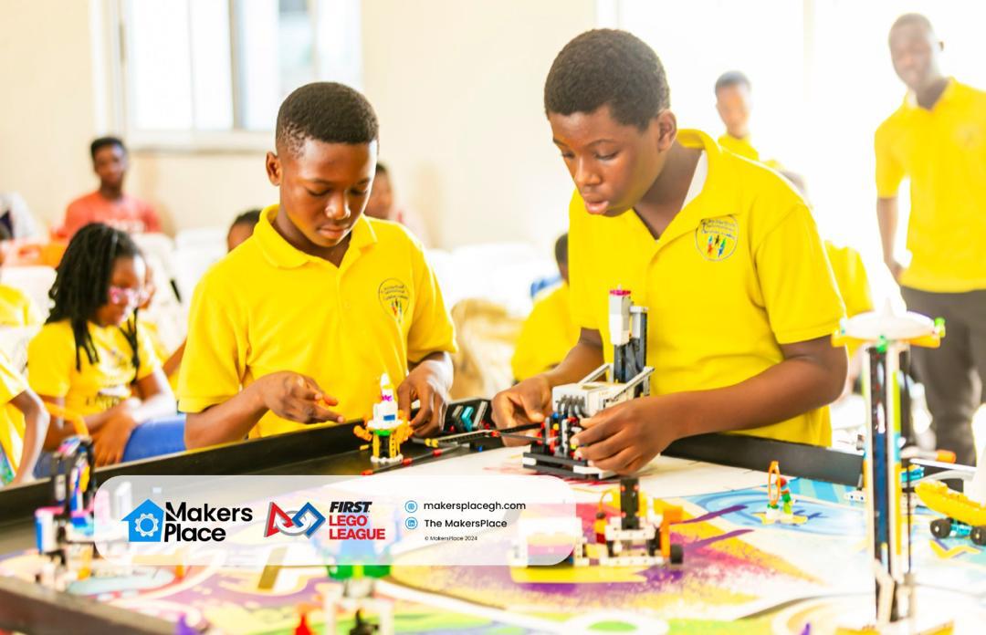 Two primary school students setting up their robot on a FIRST LEGO League competition table